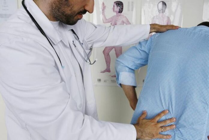Médico examinando a un paciente con dor nas costas na rexión lumbar