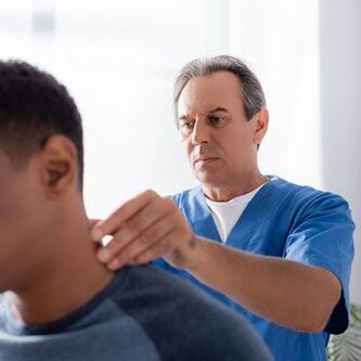 Un médico realiza un exame diagnóstico a un paciente con dor no pescozo.